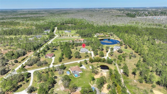 drone / aerial view with a forest view and a water view