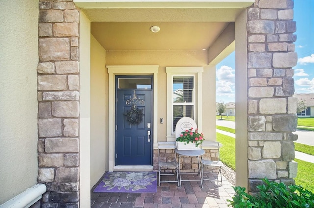 property entrance featuring stone siding and stucco siding