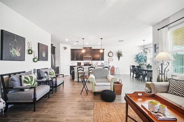 living room with recessed lighting, a textured ceiling, dark wood-type flooring, and baseboards