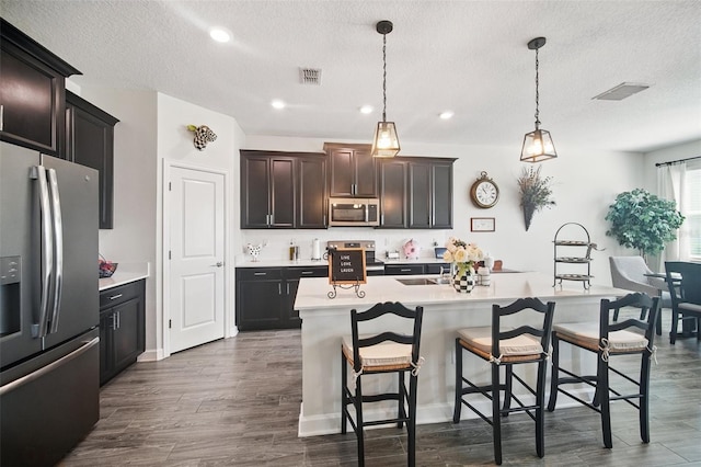 kitchen featuring stainless steel appliances, a kitchen bar, visible vents, and light countertops