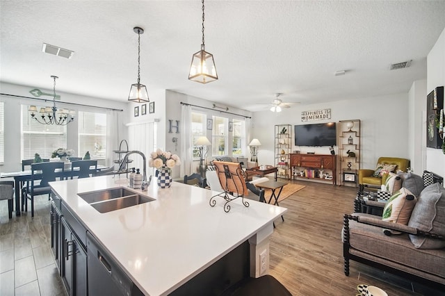 kitchen featuring visible vents, a sink, open floor plan, light countertops, and dishwasher