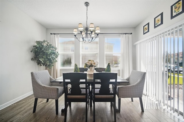 dining room featuring an inviting chandelier, wood finished floors, baseboards, and a wealth of natural light