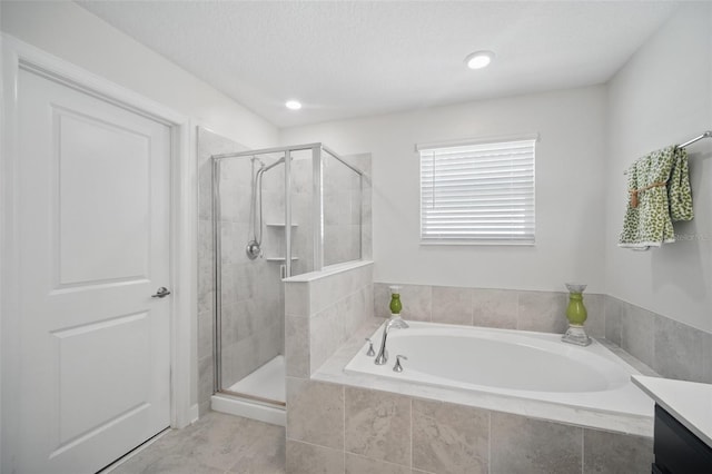 bathroom featuring a garden tub, a shower stall, and a textured ceiling