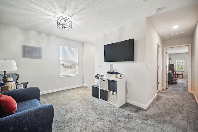 carpeted living room with baseboards and a textured ceiling