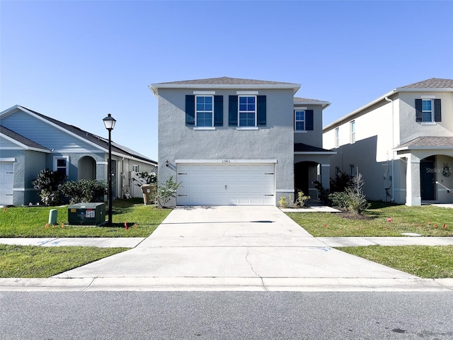 traditional-style house featuring stucco siding, a front yard, a garage, and driveway