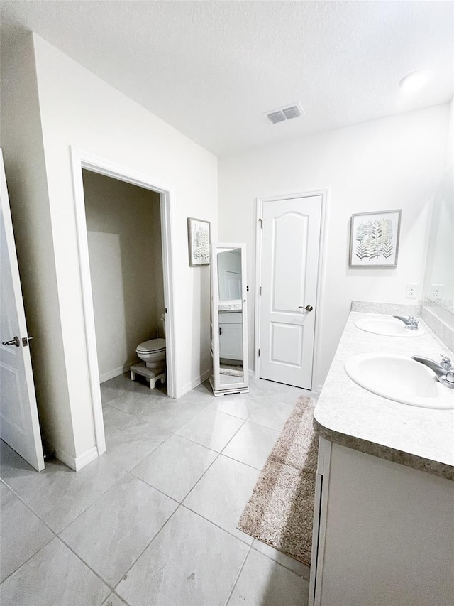 full bathroom featuring a sink, visible vents, toilet, and double vanity