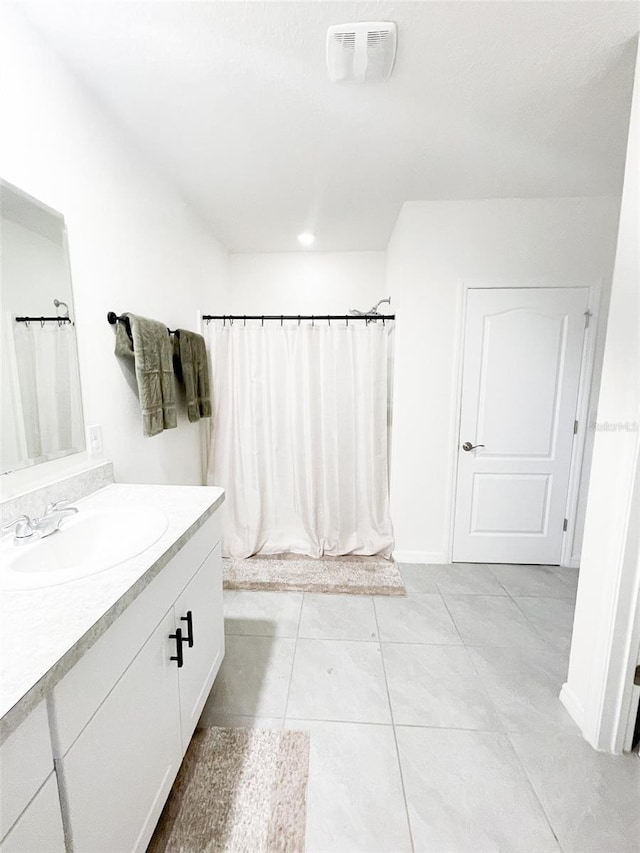 full bath with visible vents, baseboards, a shower with shower curtain, tile patterned floors, and vanity