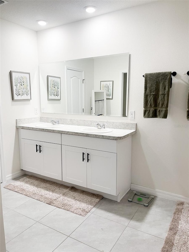 full bathroom featuring double vanity, tile patterned floors, and a sink