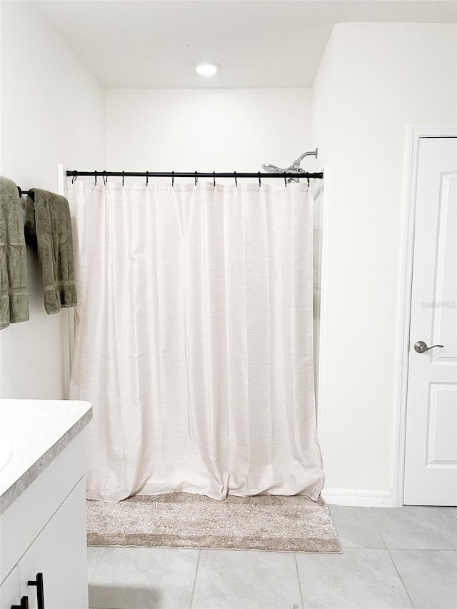 bathroom with tile patterned flooring, a shower with curtain, and vanity