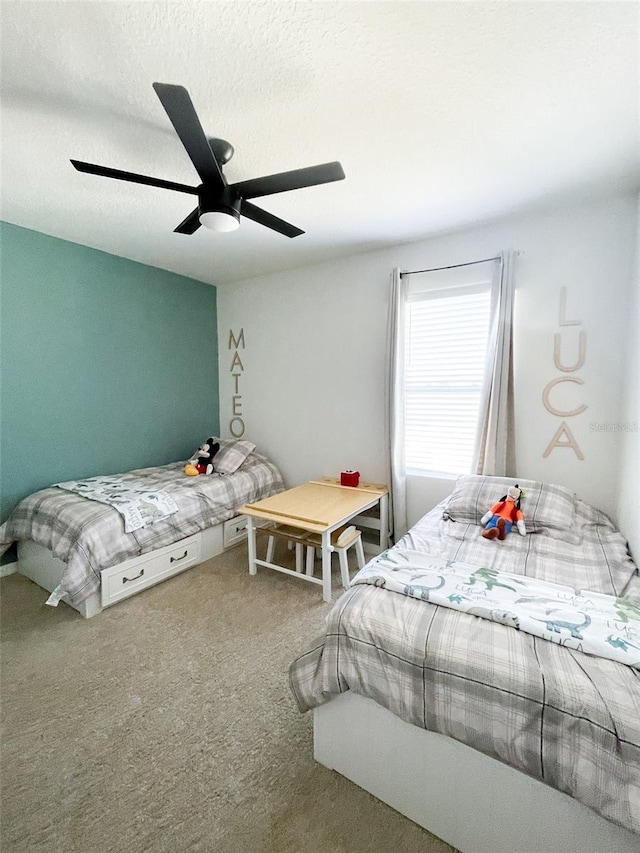 bedroom featuring a ceiling fan, carpet flooring, and a textured ceiling