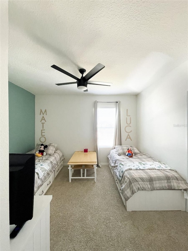 carpeted bedroom with a ceiling fan and a textured ceiling