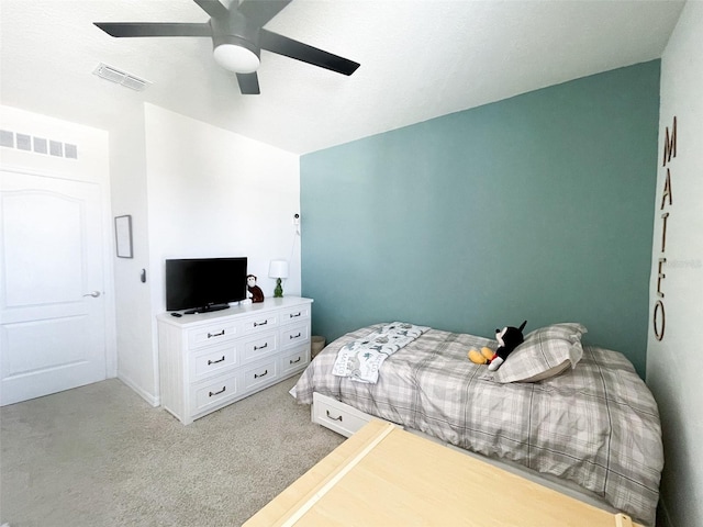 bedroom with visible vents, light colored carpet, and ceiling fan