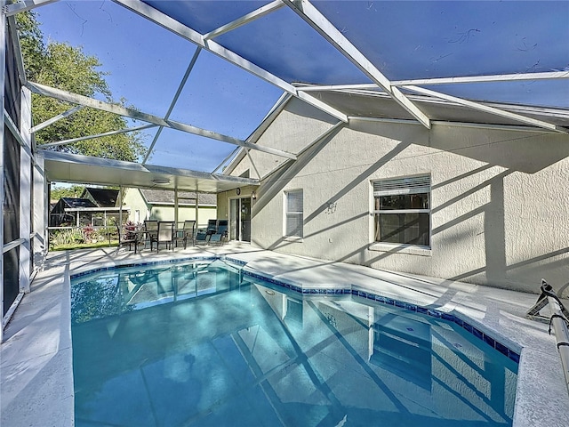 pool with glass enclosure and a patio