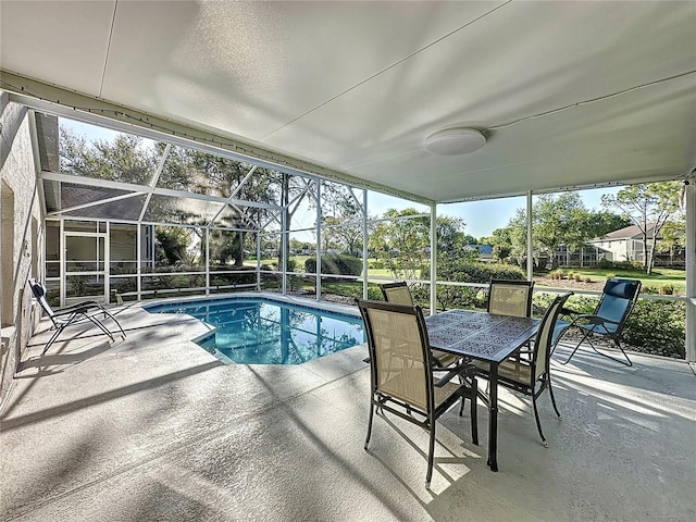 pool featuring glass enclosure, outdoor dining area, and a patio area