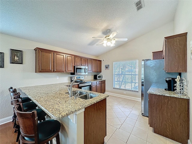 kitchen with visible vents, ceiling fan, lofted ceiling, a peninsula, and stainless steel appliances