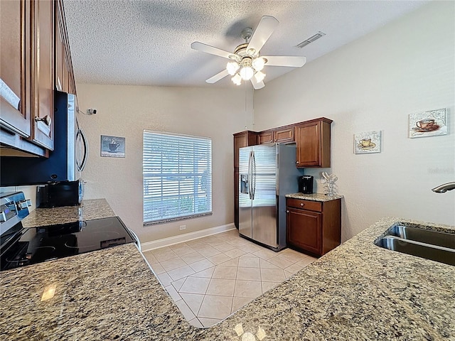 kitchen featuring visible vents, ceiling fan, appliances with stainless steel finishes, a textured ceiling, and a sink