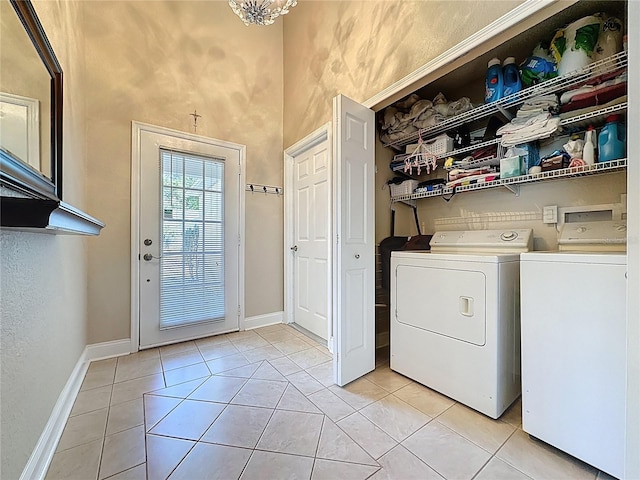 laundry room featuring washer and clothes dryer, laundry area, baseboards, and light tile patterned flooring