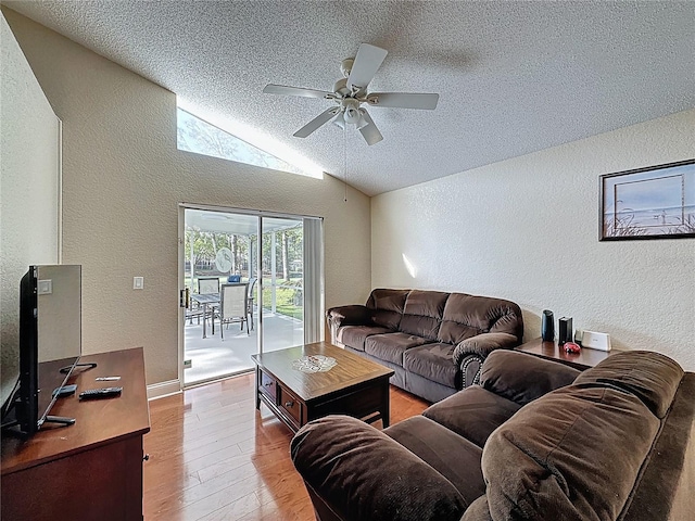 living room with light wood-type flooring, ceiling fan, and a textured wall