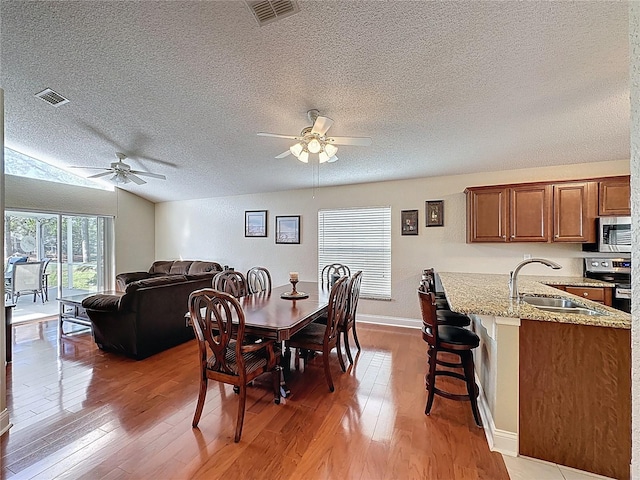 dining space with visible vents, light wood finished floors, and ceiling fan