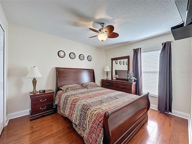 bedroom with baseboards, a textured ceiling, and wood finished floors