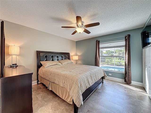 bedroom with baseboards, a textured ceiling, and a ceiling fan