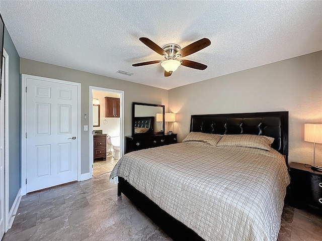 bedroom featuring visible vents, ensuite bathroom, a ceiling fan, a textured ceiling, and baseboards