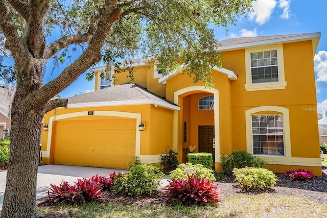 traditional home with stucco siding, concrete driveway, and a garage