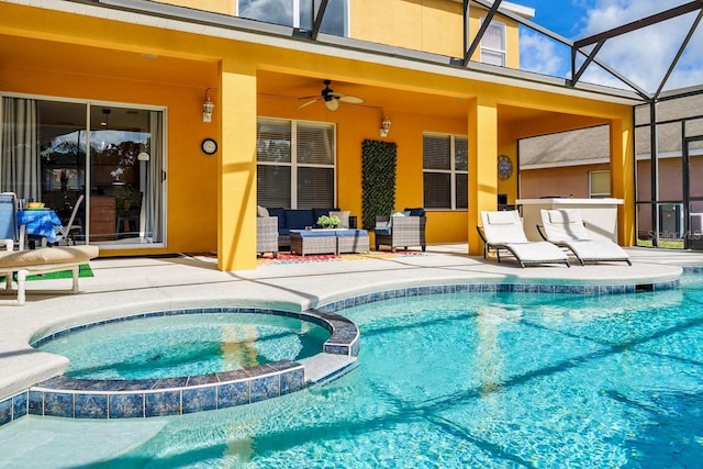 view of pool with a pool with connected hot tub, ceiling fan, glass enclosure, outdoor lounge area, and a patio area