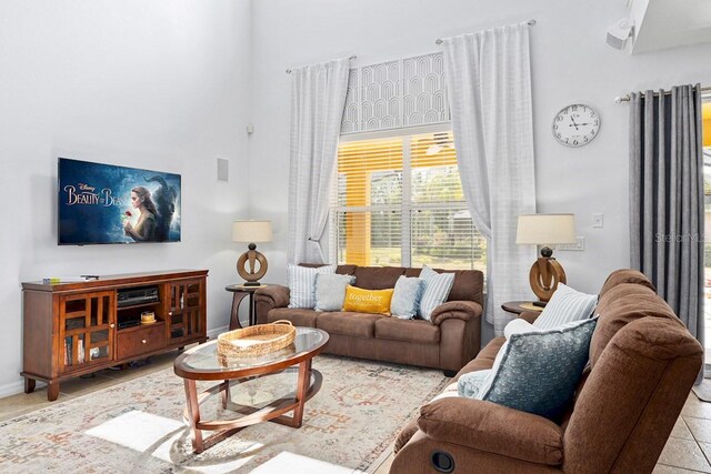 living room with tile patterned floors, a high ceiling, and baseboards