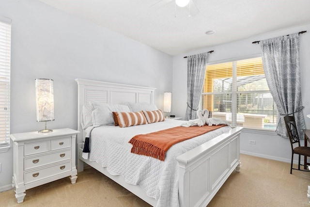 bedroom with light colored carpet, baseboards, and ceiling fan