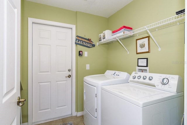 laundry area featuring baseboards, independent washer and dryer, light tile patterned flooring, and laundry area