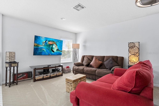 living area featuring visible vents, carpet flooring, a textured ceiling, and baseboards