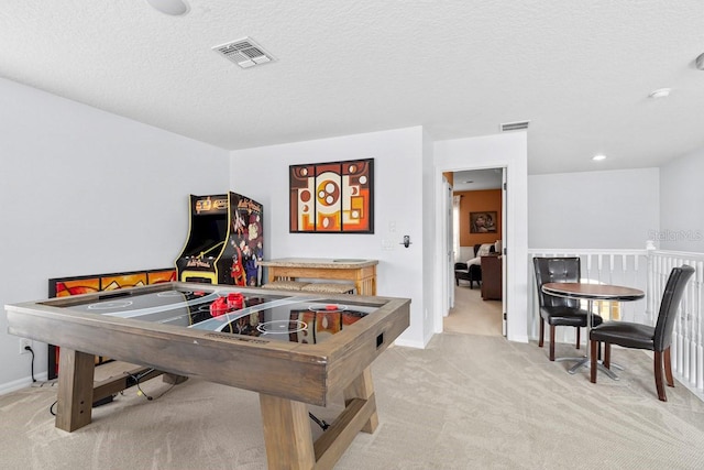 recreation room featuring a textured ceiling, visible vents, and light carpet