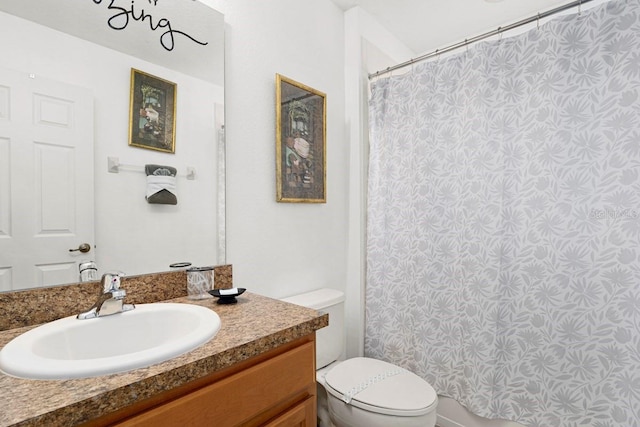 bathroom featuring vanity, curtained shower, and toilet