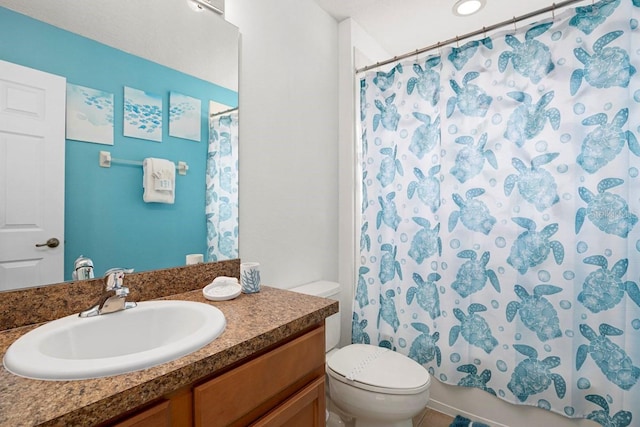 bathroom featuring curtained shower, toilet, and vanity