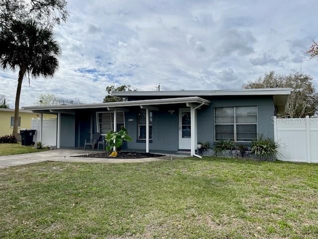 view of front facade with an attached carport, a front lawn, fence, and driveway