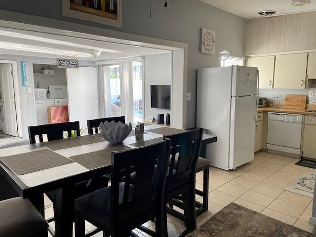 dining space with washer and dryer, visible vents, and light tile patterned flooring