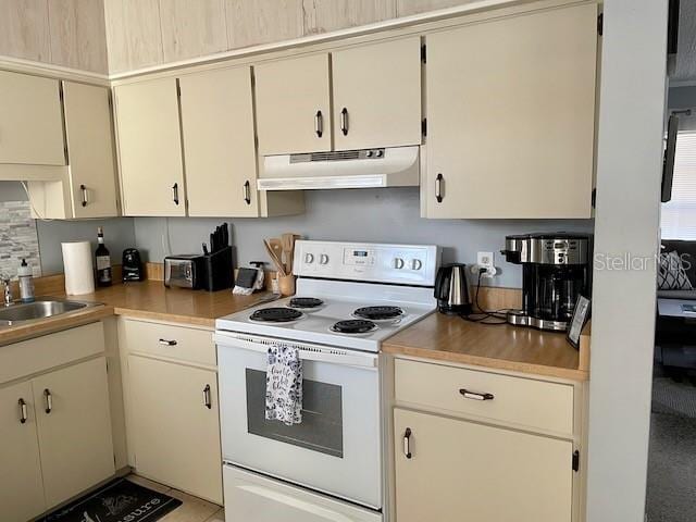 kitchen featuring white electric range oven, light countertops, under cabinet range hood, and a sink