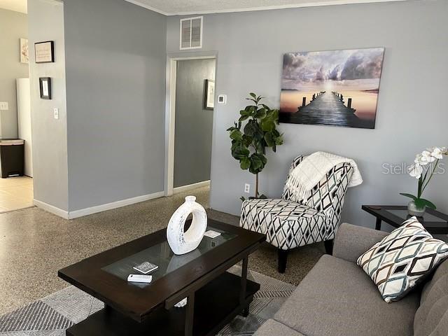 living room with visible vents, speckled floor, and baseboards