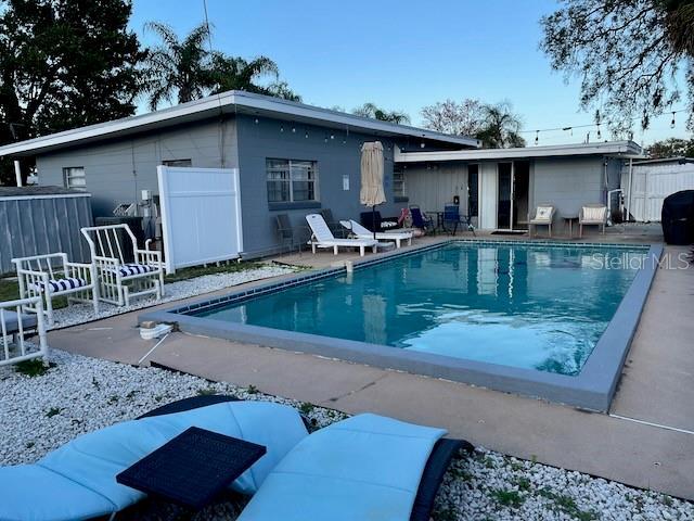 back of property featuring a fenced in pool, a patio, and fence