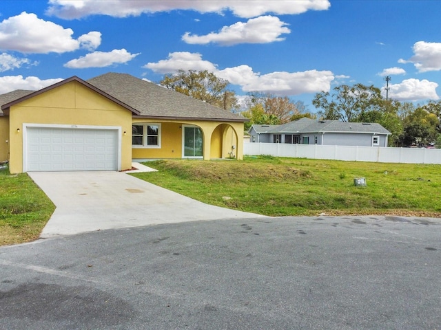 ranch-style house with stucco siding, an attached garage, a front lawn, and fence