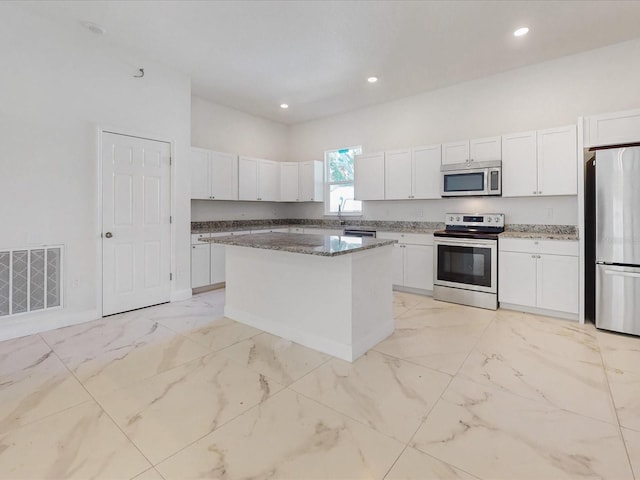 kitchen featuring visible vents, marble finish floor, appliances with stainless steel finishes, and white cabinetry