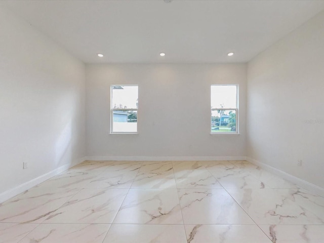 spare room with recessed lighting, baseboards, and marble finish floor