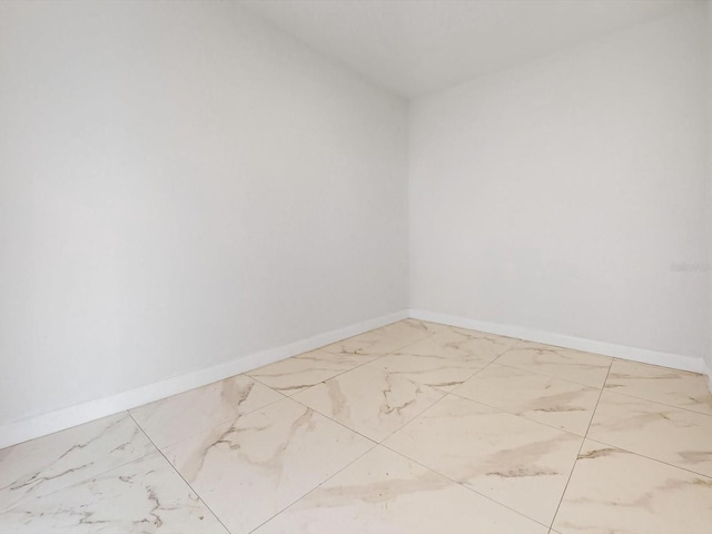 empty room with baseboards and marble finish floor