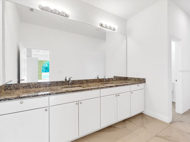 bathroom featuring vanity, baseboards, and marble finish floor