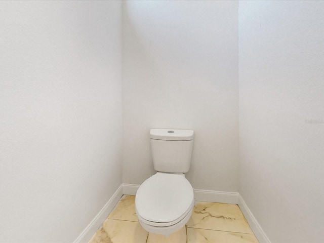 bathroom with toilet and baseboards