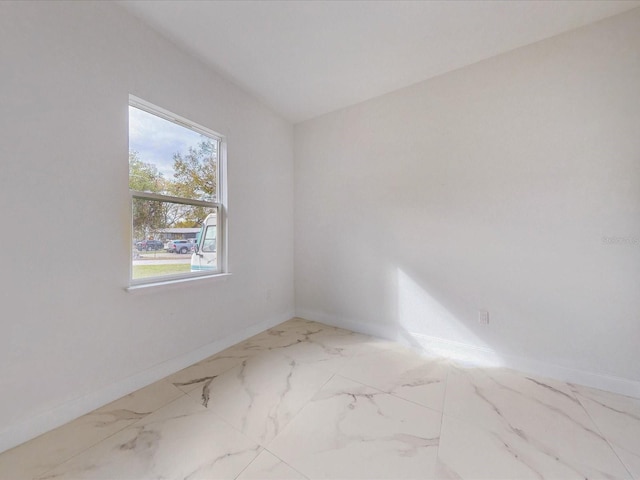 spare room with marble finish floor and baseboards