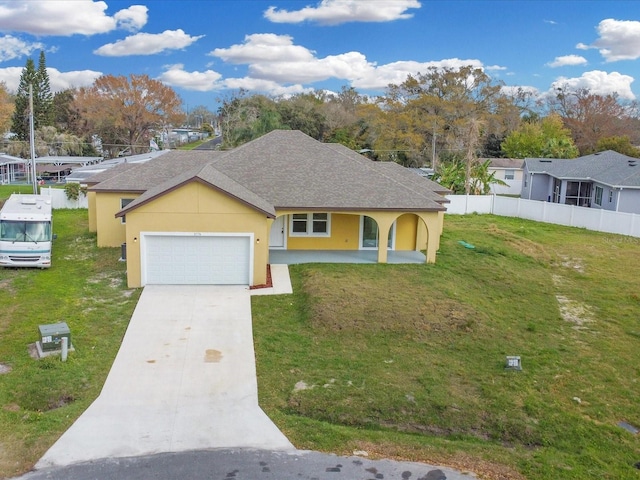 single story home featuring a front lawn, an attached garage, fence, and stucco siding