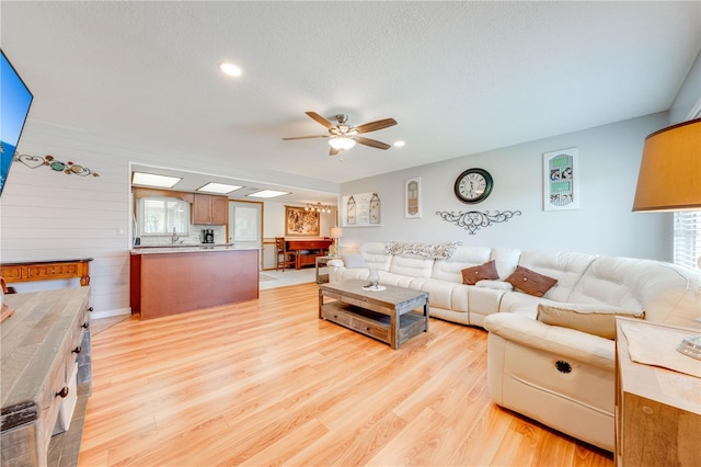 living room with ceiling fan, light wood-style flooring, and recessed lighting