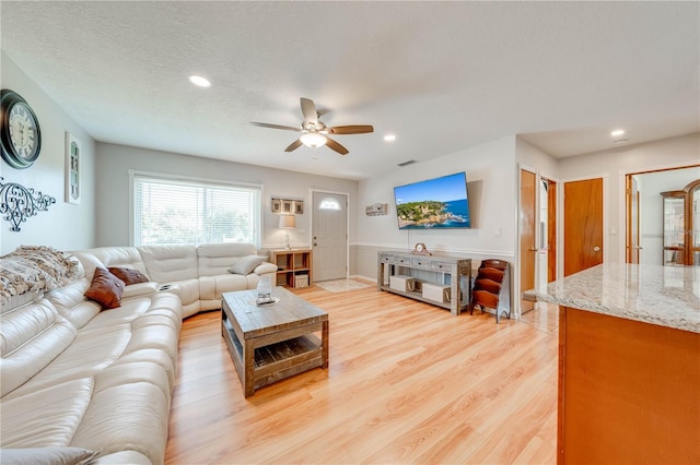 living area with visible vents, light wood-style flooring, recessed lighting, ceiling fan, and a textured ceiling